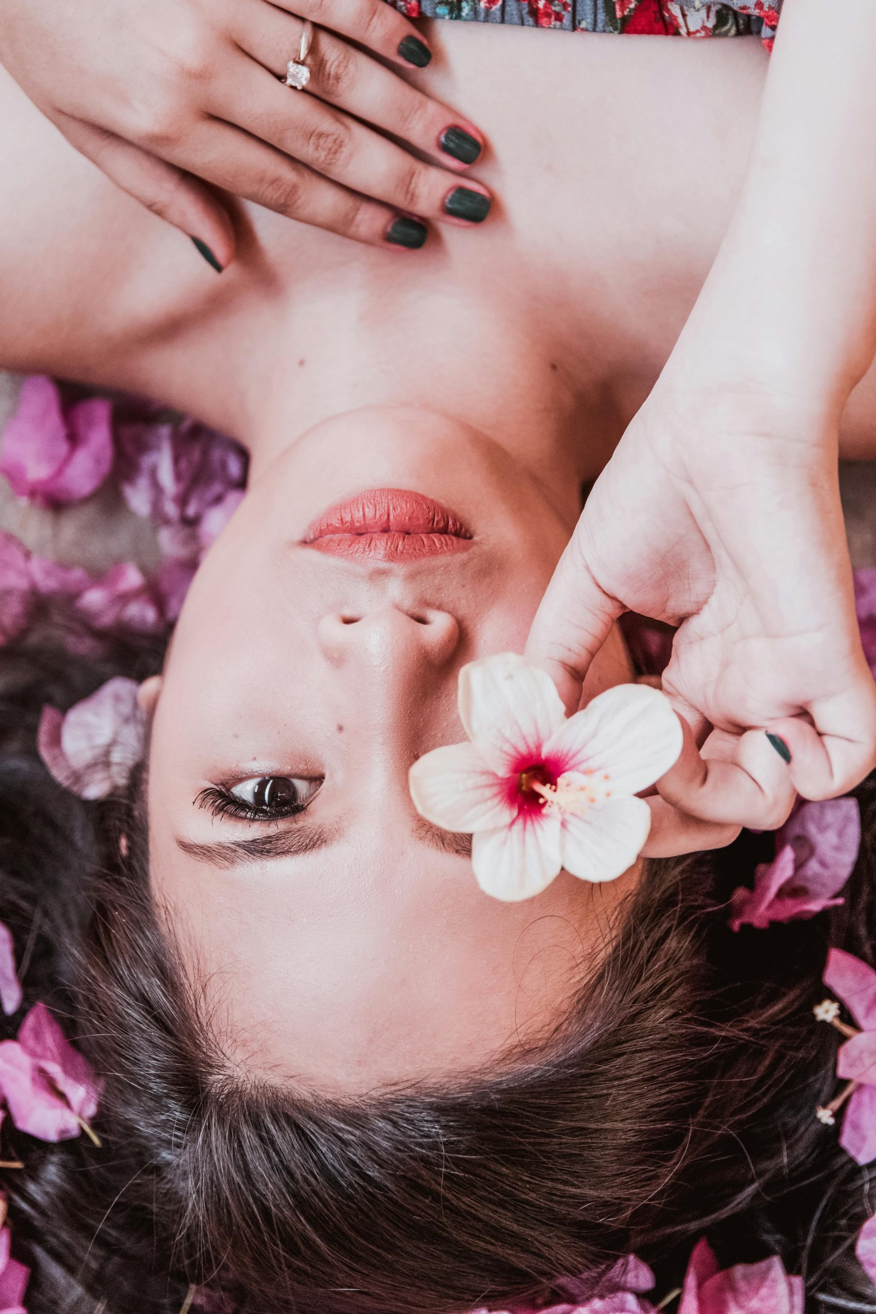 pexels photo 2144413 2144413 Elegant photoshoot featuring a woman holding a pink flower amidst petals.